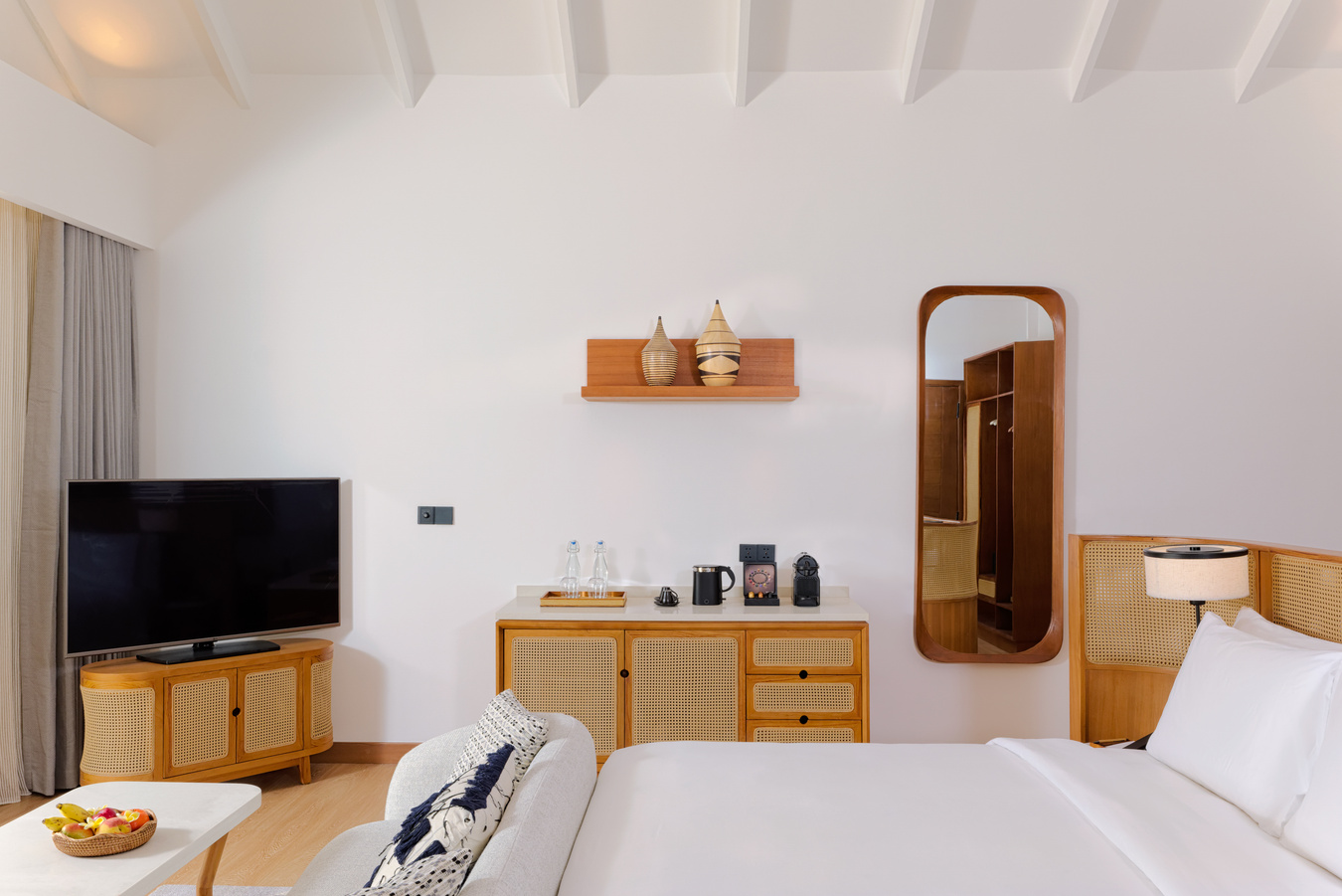 Light-filled villa bedroom with warm timber furnishings